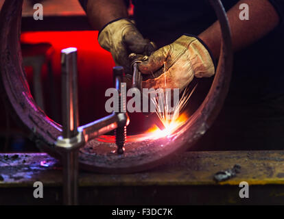 Welder working in metal workshop Stock Photo