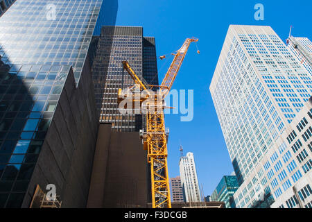 Low angle view of crane among skyscrapers Stock Photo
