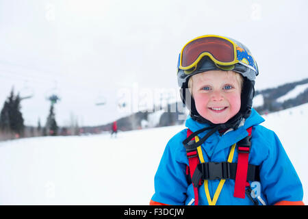 Smiley little boy (5) wearing ski suit in mountains