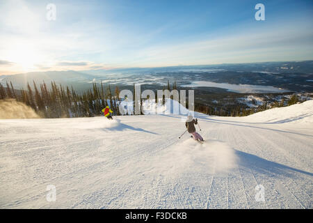 Two people on ski slope at sunlight Stock Photo