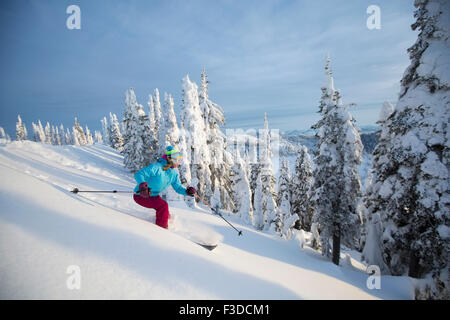 Mature woman speeding on ski slope Stock Photo