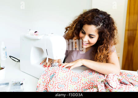 Woman using sewing machine Stock Photo