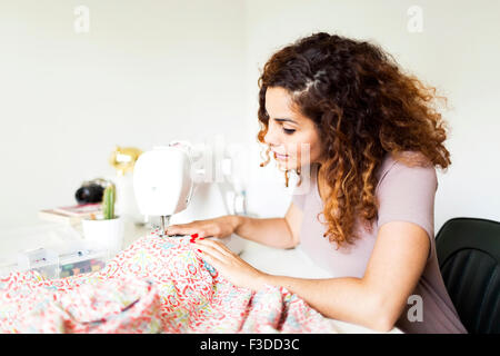 Woman using sewing machine Stock Photo