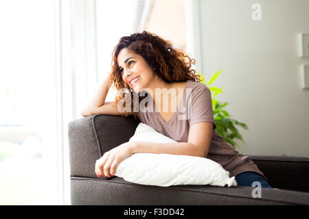 Woman sitting on sofa Stock Photo