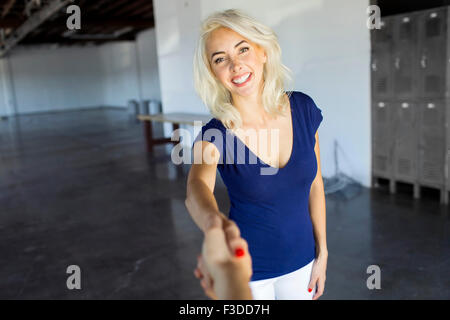 Women shaking hands in warehouse Stock Photo