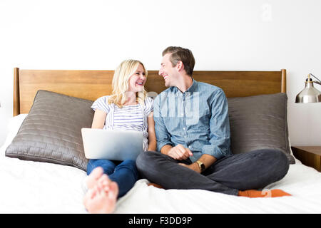 Couple sitting on bed Stock Photo