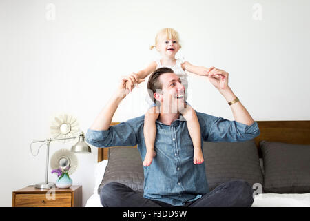 Portrait of father carrying daughter (2-3) on shoulders Stock Photo