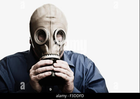 Studio shot of man trying to breath in gas mask Stock Photo