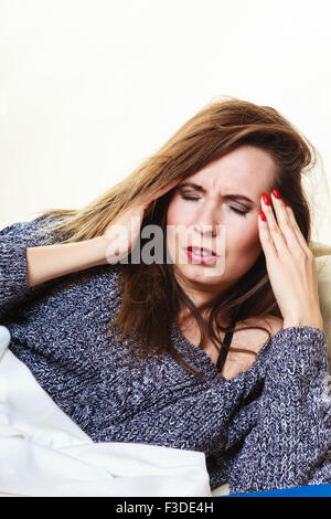 Health balance sleep deprivation concept. Woman lying on couch suffering from head pain taking power nap Stock Photo