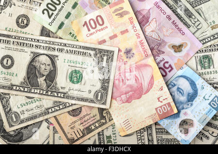 Dollars and Mexican Pesos assorted bills cash pile background Stock Photo