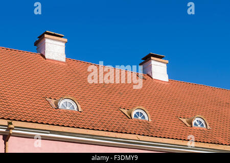 Retro style tiled roof with chimneys and mansard windows Stock Photo