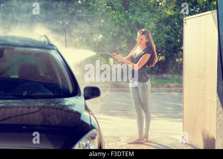 Pretty woman in the car wash - hand wash Stock Photo