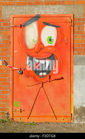 Door embellished with cartoon grafitti graffiti of face, England UK Stock Photo