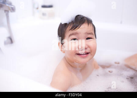 Baby boy enjoying a bubble bath, portrait Stock Photo