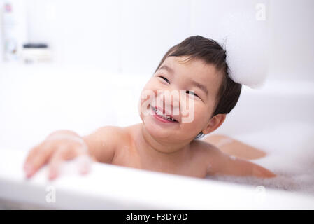 Baby boy enjoying a bubble bath, portrait Stock Photo