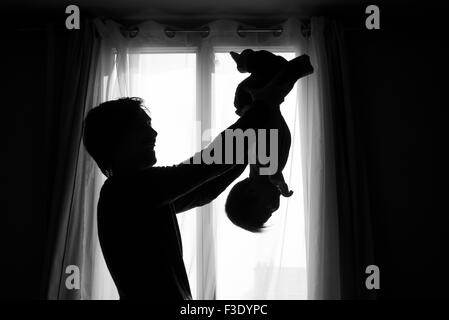 Father holding baby upside down Stock Photo