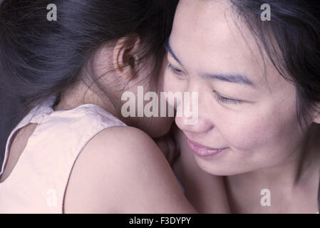 Little girl sharing secret with her mother Stock Photo
