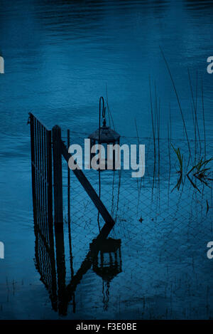 Lantern haning near gate in water Stock Photo