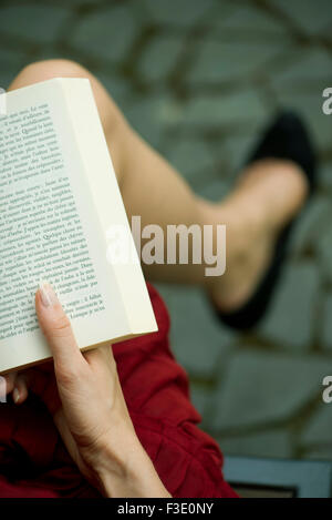 Woman reading book, over the shoulder view Stock Photo