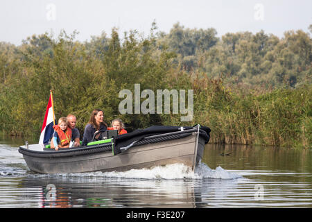 Young family sailing a rent boat in National park 'the Biesbosch', wetland natura 2000 area in the Netherlands Stock Photo