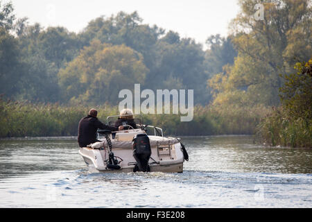 Couple sailing a boat in National Park 'the Biesbosch' during autumn in the Netherlands Stock Photo