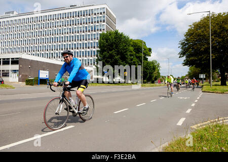 Cyclists riding past Brighton University on Lewes Road close to the finish of the London Brighton bike ride Stock Photo
