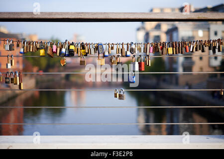 Padlocks attached to wire railings of Centenary bridge over the river Aire in The Calls area of Leeds, Yorkshire. UK Stock Photo
