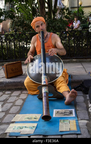 Street performer playing der Hang and a harmonium at the same time as a didgeridoo on the island republic of Cuba Stock Photo