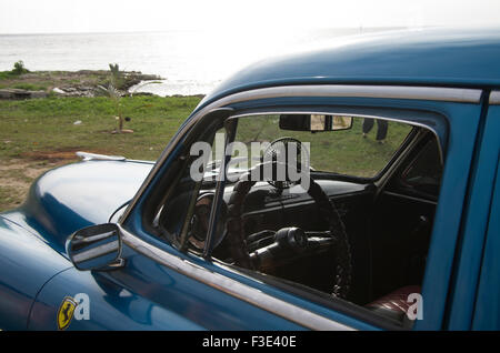 Antique blue Chevrolet American vintage car on the grass on the beach in Playa Larga, Republic of Cuba Stock Photo