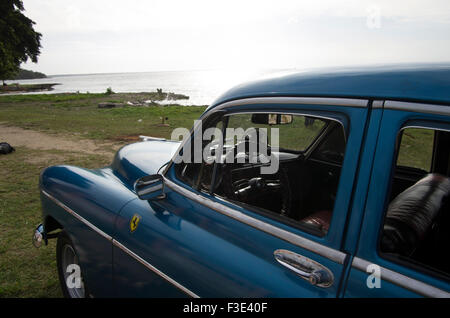 Antique blue Chevrolet American vintage car on the grass on the beach in Playa Larga, Republic of Cuba Stock Photo