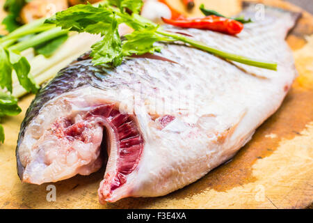 Fish and spices on the chopping block. Stock Photo