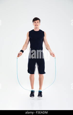 Full length portrait of a man jumping with skipping rope isolated on a white background Stock Photo