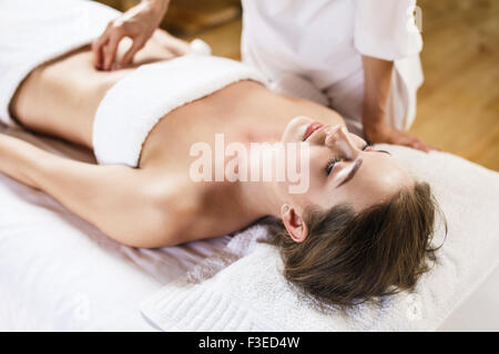 Woman enjoys massage of tummy at the health spa Stock Photo