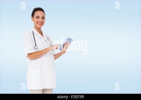 Composite image of pretty nurse using tablet pc Stock Photo