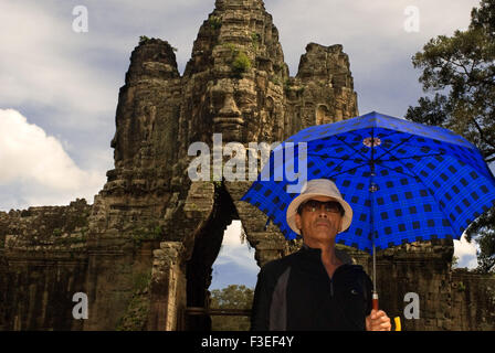 Asian Tourist in the gateway to Angkor Thom. Angkor Thom is undeniably an expression of the highest genius. It is, in three dime Stock Photo