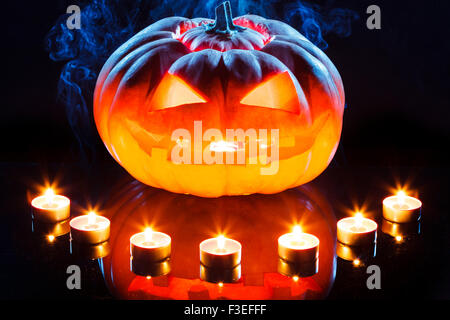 Halloween pumpkin with scary face and burning candle Stock Photo