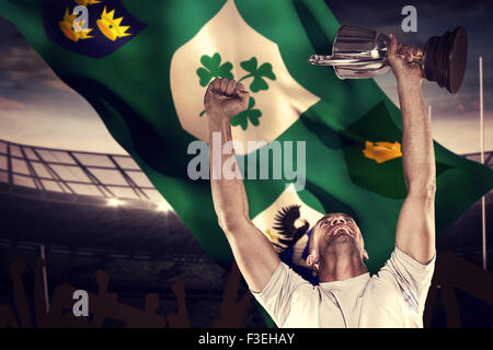 Composite image of happy rugby player holding trophy Stock Photo