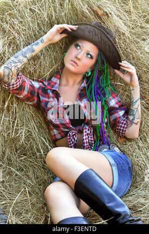 young tattooed  stylish woman with dreadlocks in cowgirl style Stock Photo