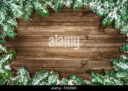 Wood planks background framed with snow covered fir twigs, a studio shot with nice bright lighting, highly suitable for Christma Stock Photo