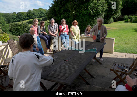 Family playing table tennis on garden table, Monmouth, Powys, England, UK Stock Photo