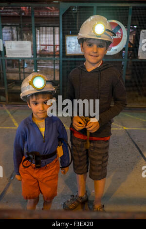 2 boys with safety hats waiting for an underground tour of Big Pit National Coal Museum, Blaenavon, South Wales, UK Stock Photo