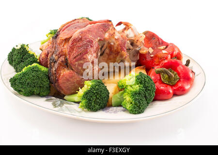 Baked pork knuckle with vegetables. Stock Photo