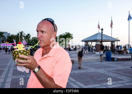 Key West Florida,Keys Mallory Square Dock,sunset celebration,festival,man men male,sipping,straw,pina colada,alcoholic drink drinks,FL150508083 Stock Photo