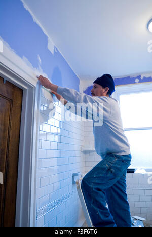 Mexican man tiling a bathroom wall with subway tiles Stock Photo - Alamy