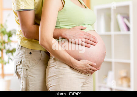 Mom and dad with hands on baby Stock Photo