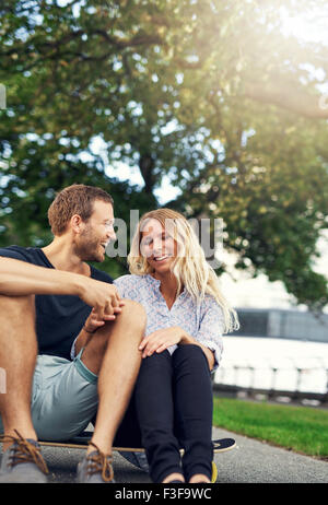 Couple fooling around on a skateboard, big city couple Stock Photo