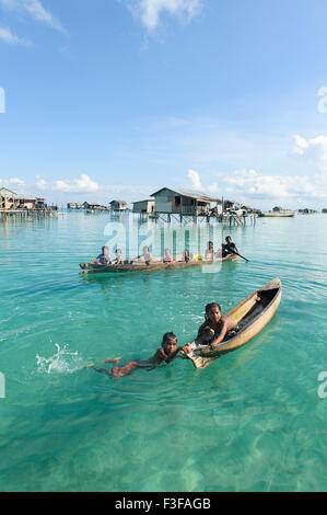 Unidentified Borneo Sea Gypsy kids on a canoes  in Mabul Maiga Island, Sabah Borneo, Malaysia. Stock Photo