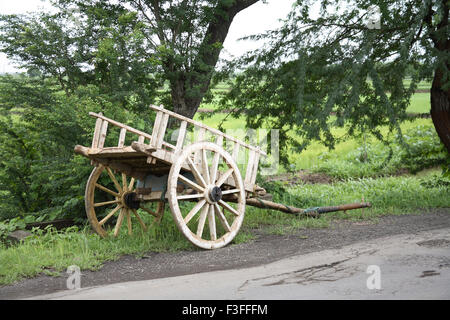 Bullock cart without bulls parked at the side of the road ; India Stock Photo