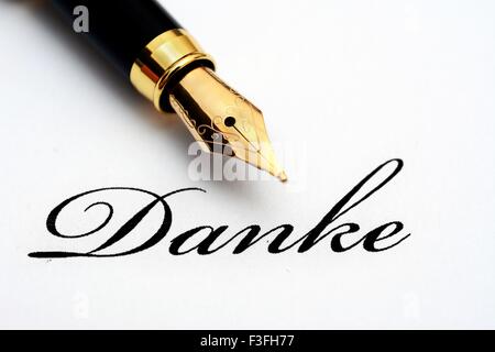 Fountain pen on danke text - A word of Germanic origin, meaning thanks/thank you; Stock Photo