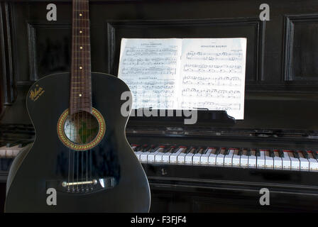 Musical Instruments ; Spanish Guitar and an upright Piano Stock Photo